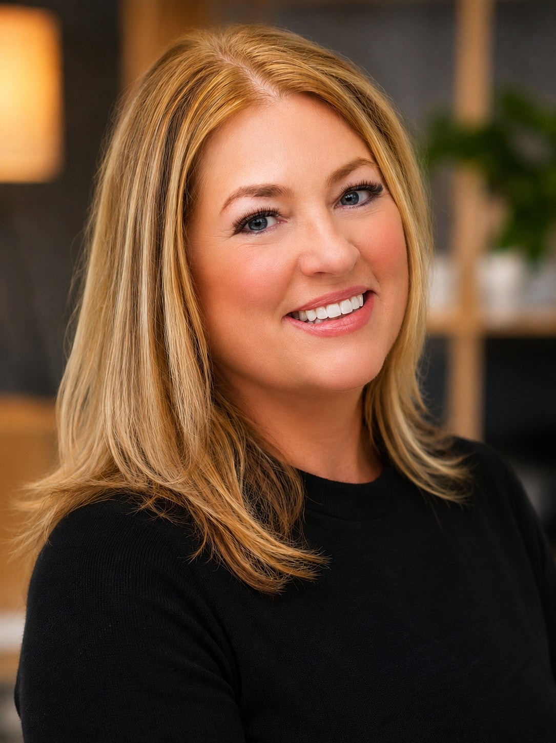 Smiling woman with long blonde hair in black.