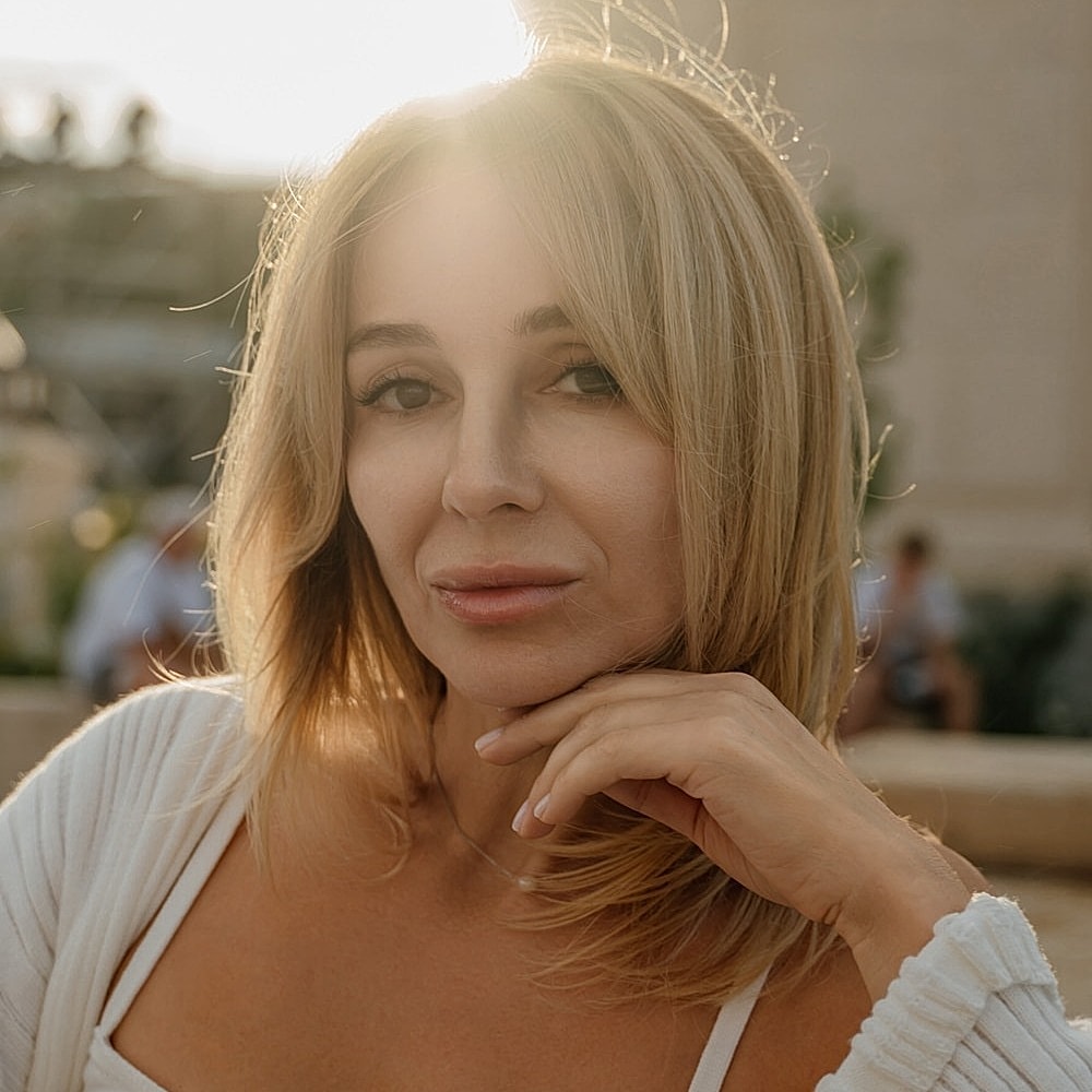 Portrait of a woman with blonde hair outdoors.
